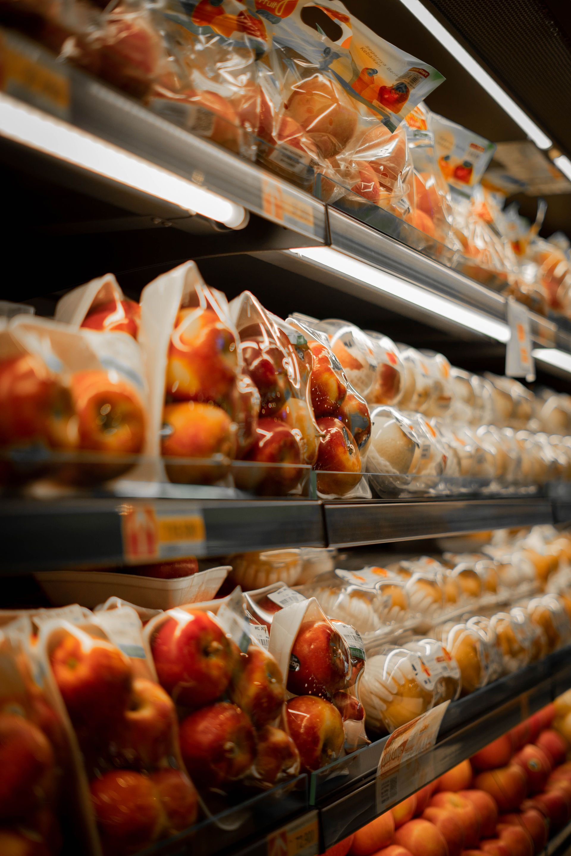 Rows of packaged apples and other produce on grocery store shelves