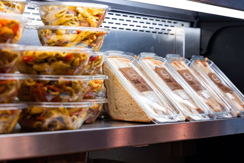 Packaged salads and sandwiches displayed in a refrigerated deli case.