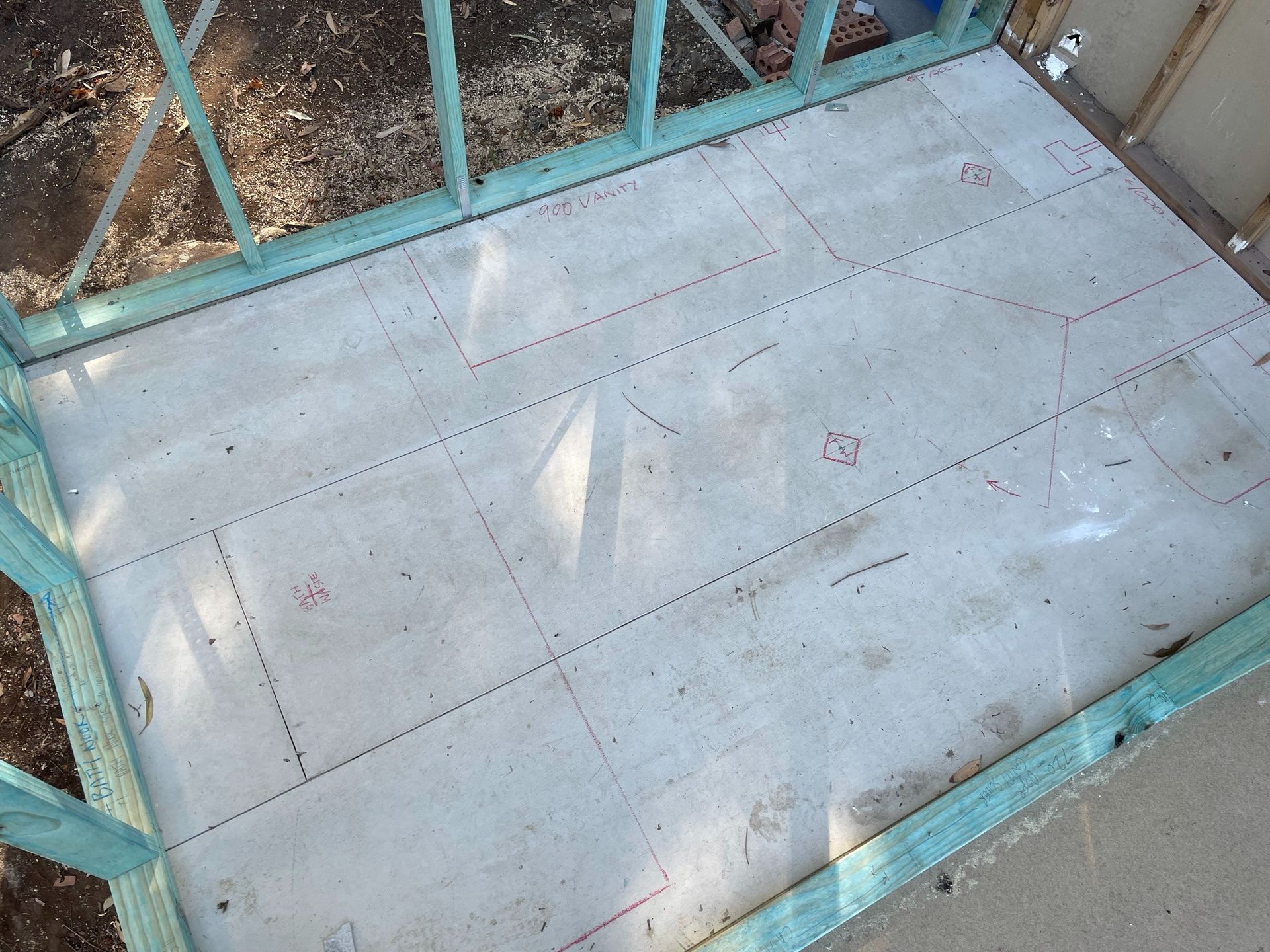 Empty concrete porch with teal metal railing and a few visible cracks and dirt marks