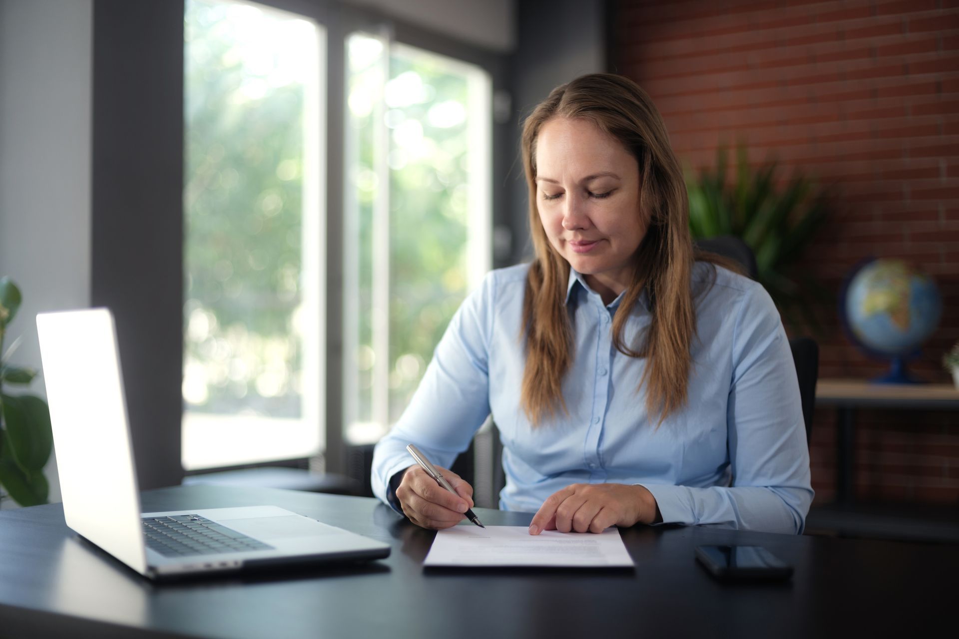 Estate planning lawyer signing an official document in her office. Estate planning lawyer signing an official document in her office.
