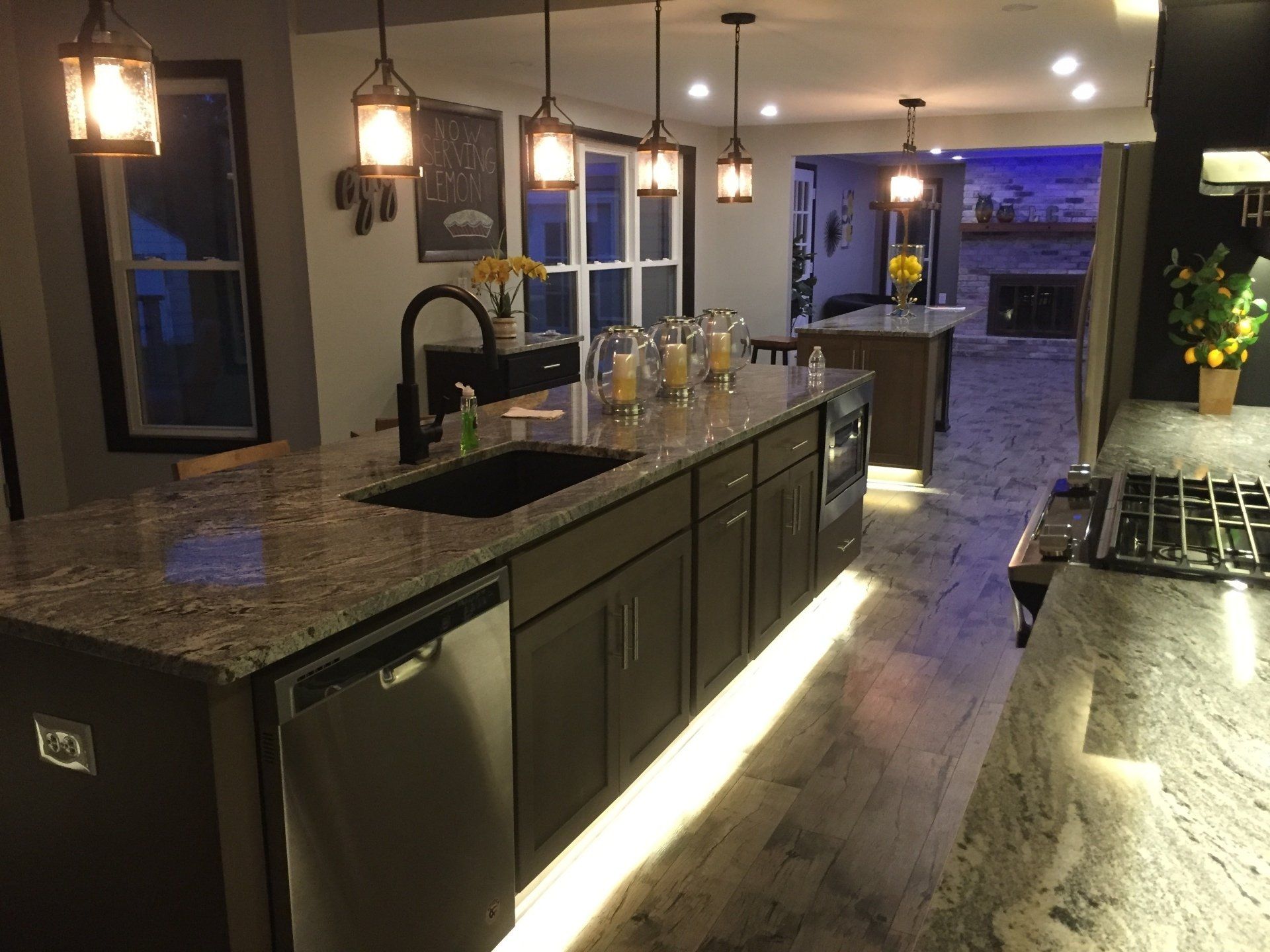 Kitchen with dark brown cabinets, granite countertops, and under-cabinet lighting.