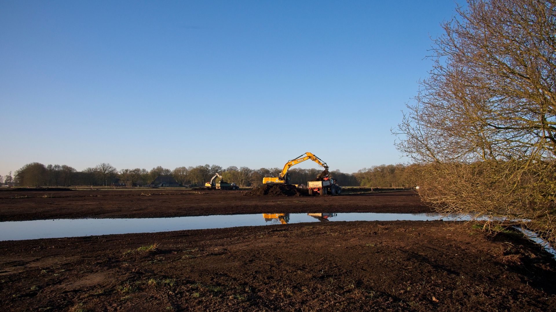 Excavator building a drain trench
