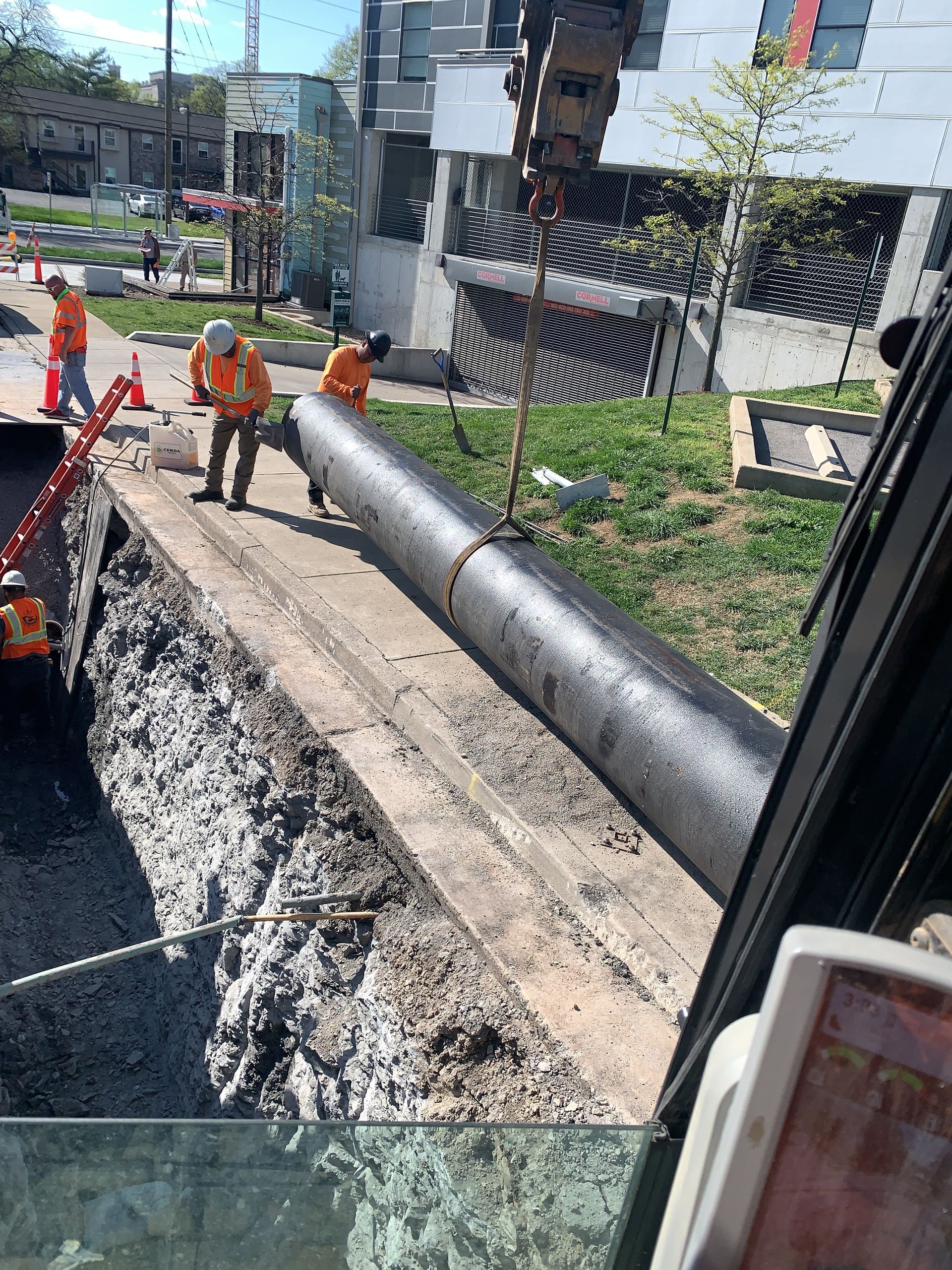 A group of construction workers are working on a large pipe.