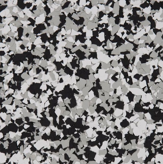 A pattern of small, irregularly shaped black, white, and gray flakes, typical of decorative epoxy flooring.