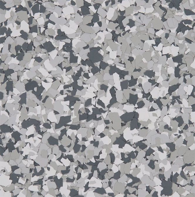 A close-up of a decorative flooring finish featuring a dense pattern of white, light gray, and dark gray vinyl flakes.