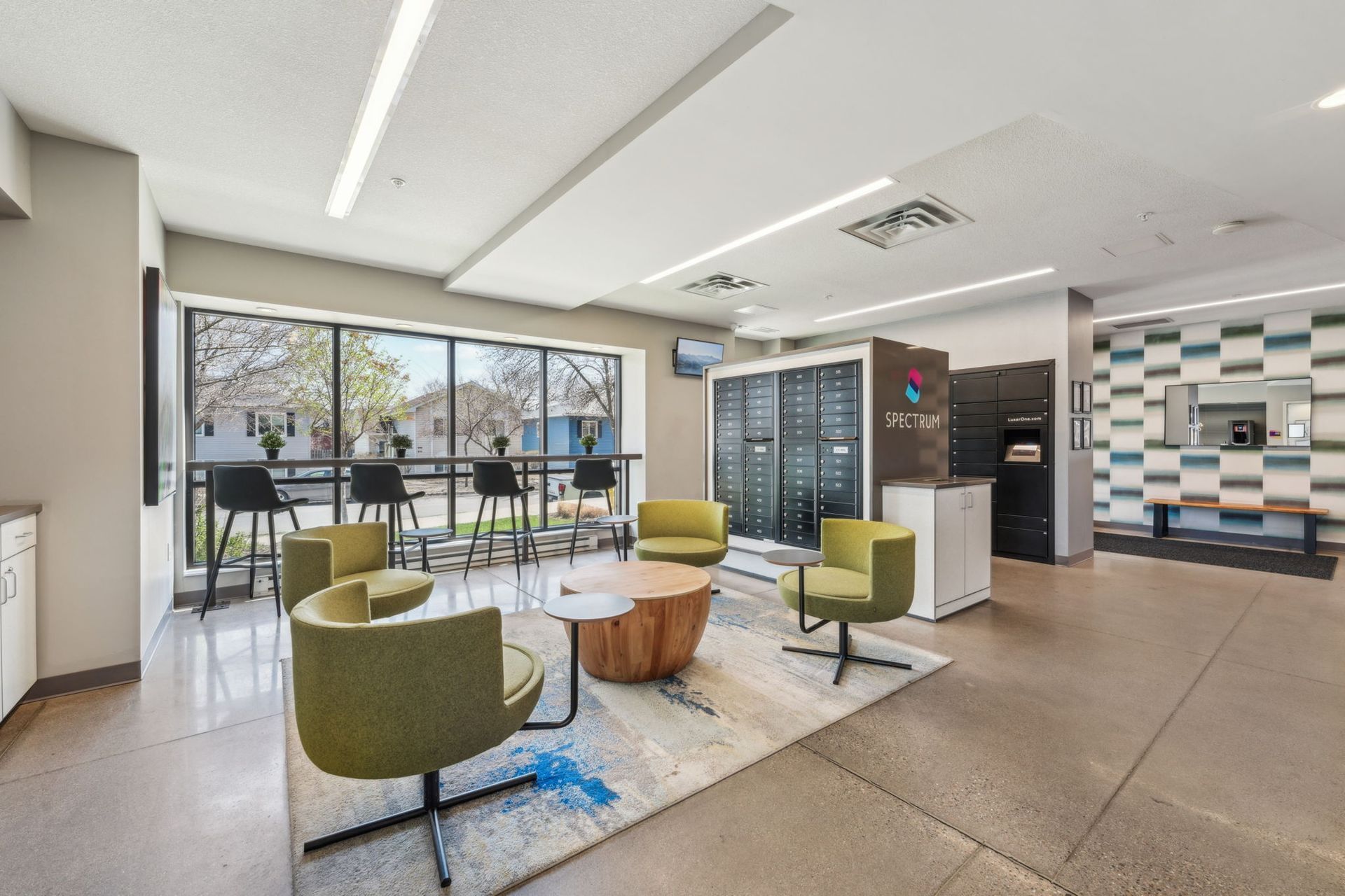 Lobby area with green chairs and secure mail at Spectrum Apartments in Minneapolis