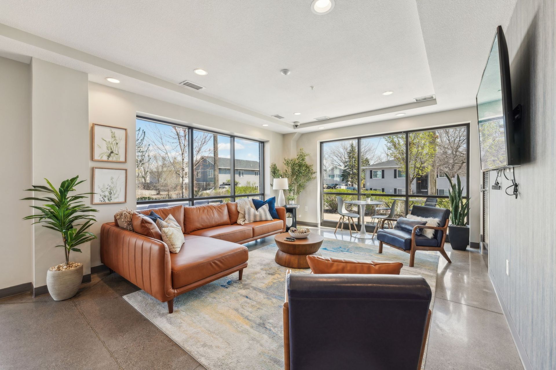 Community room with oversized windows and modern furniture at Spectrum Apartments in Minneapolis