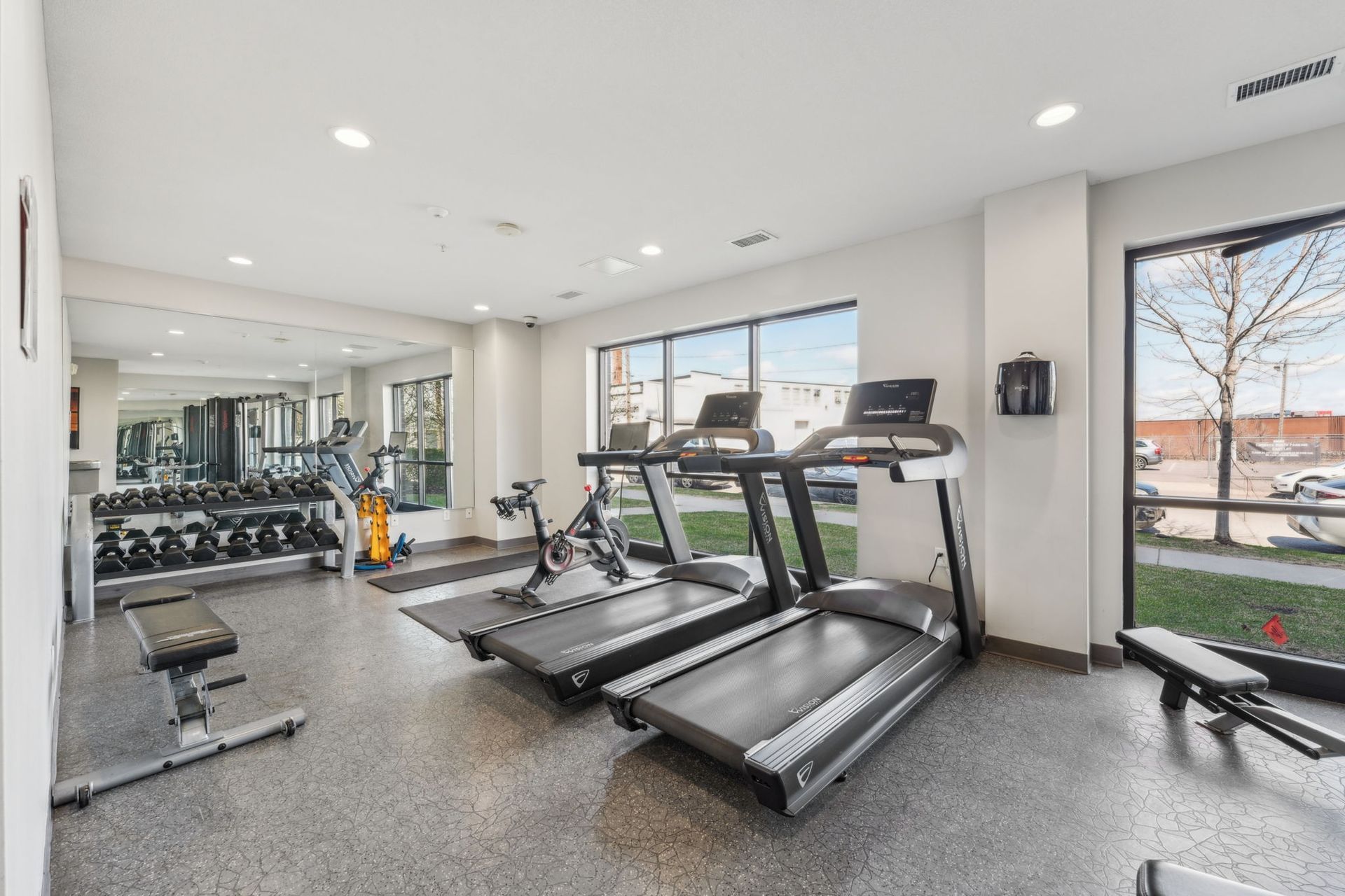 Fitness center looking out oversized windows with lots of natural light