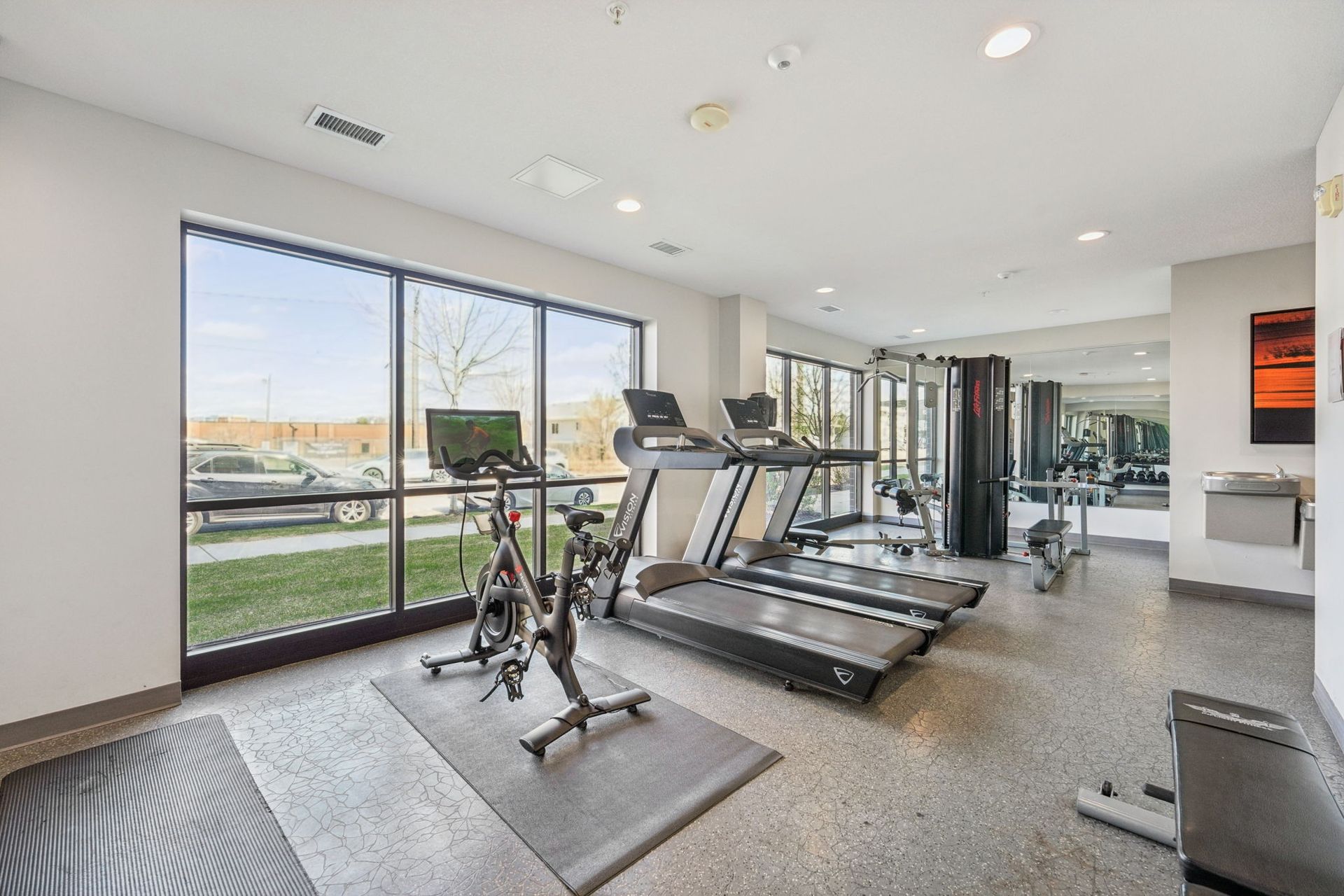 Fitness center looking out oversized windows with lots of natural light