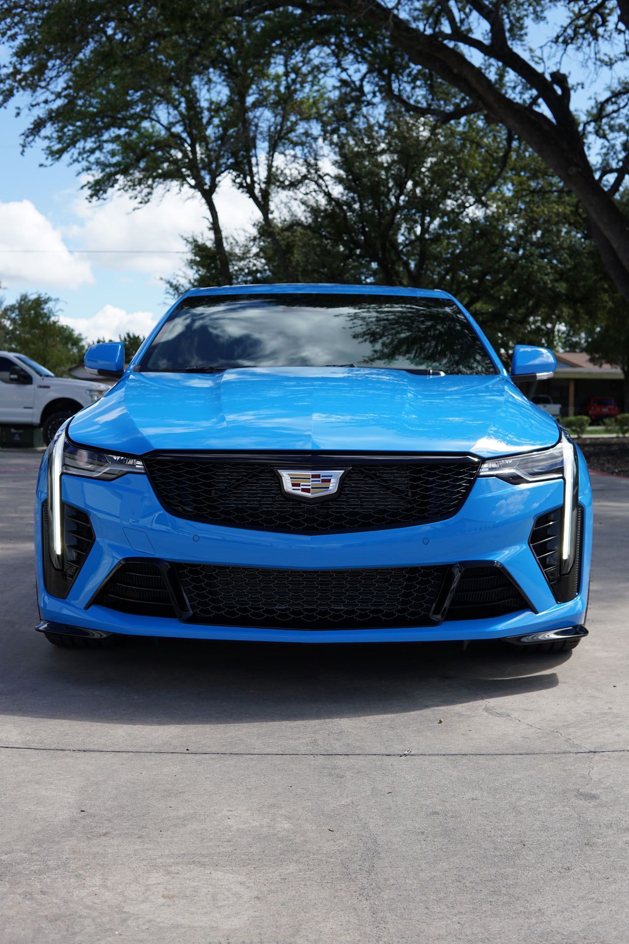 Blue Cadillac sports sedan parked on asphalt.