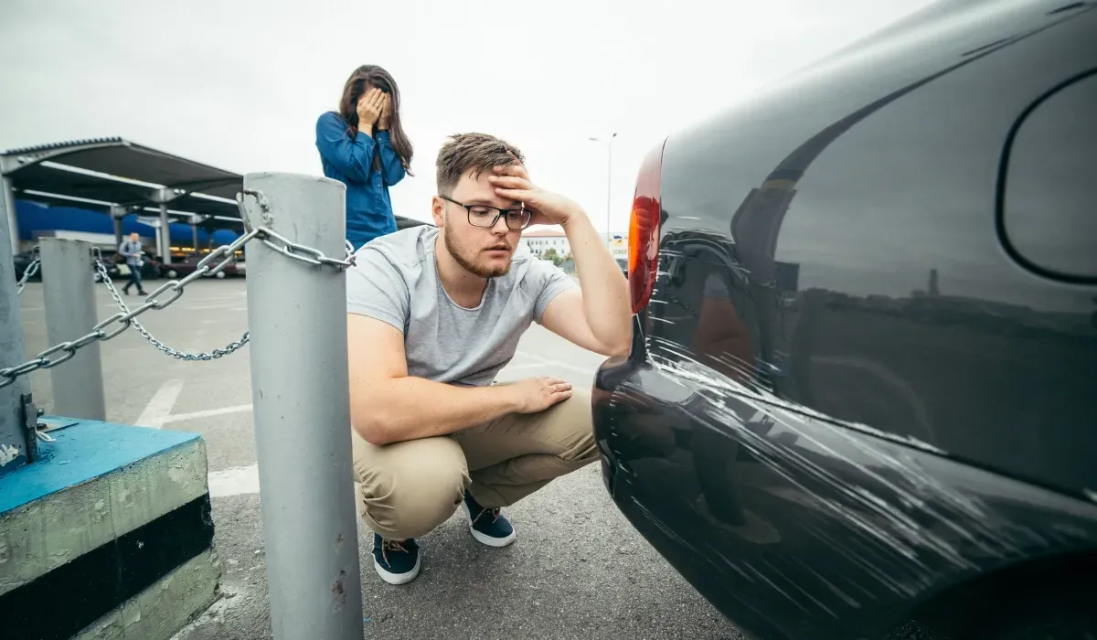 Couple reacting to scratched car