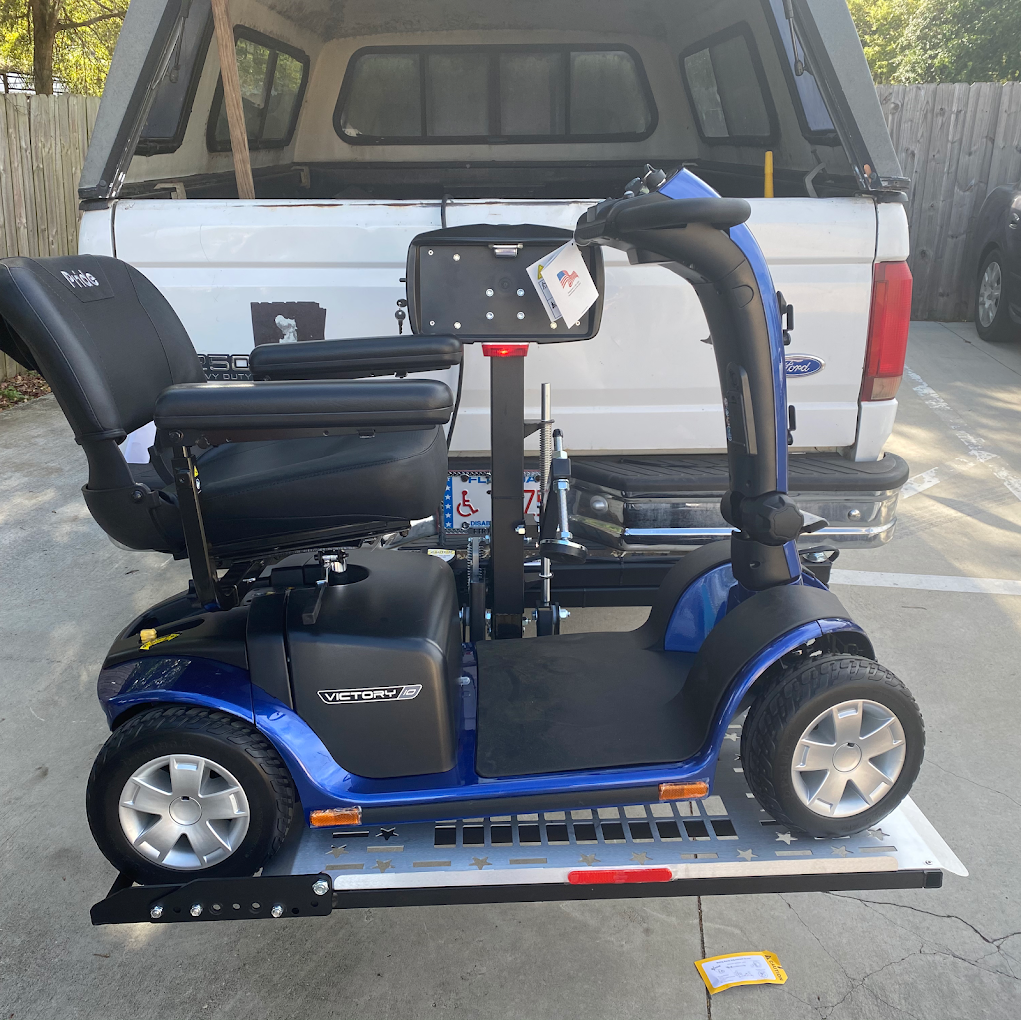 Blue mobility scooter secured on a lift at the back of a white pickup truck