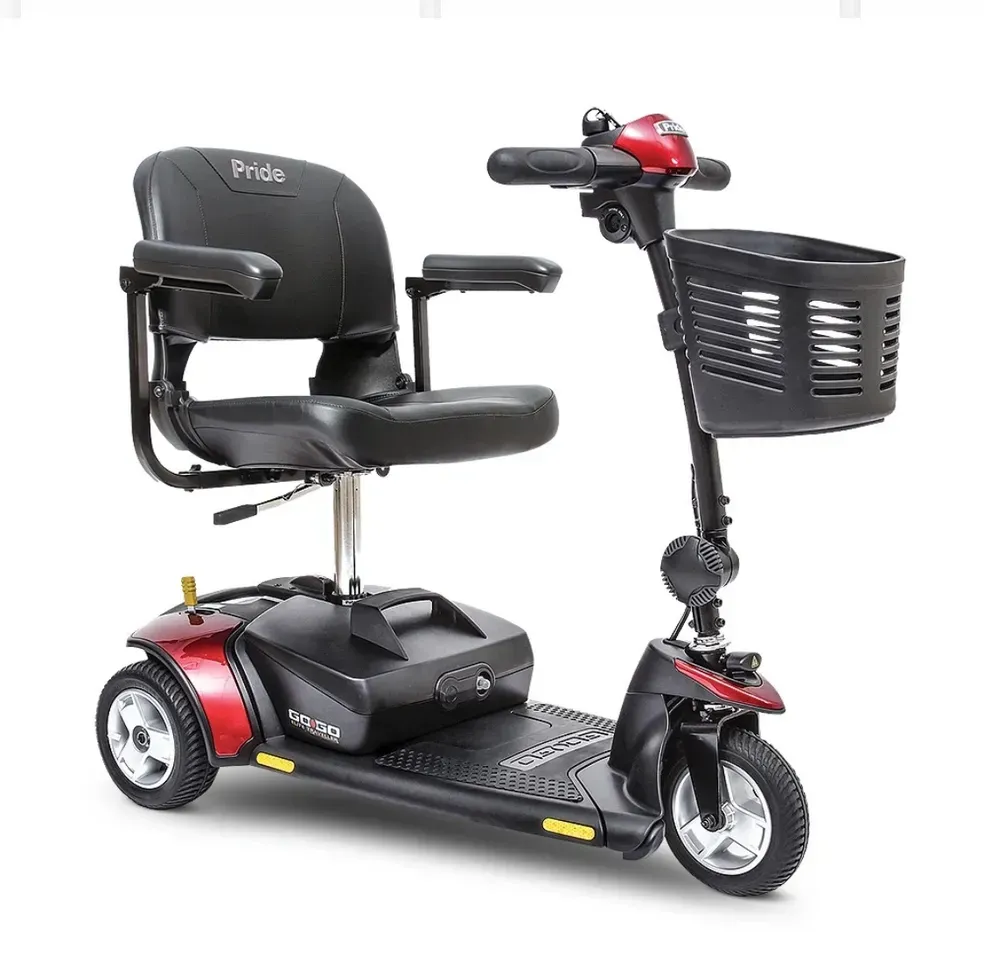 Black three-wheeled mobility scooter with seat, basket, and red accents on a white background