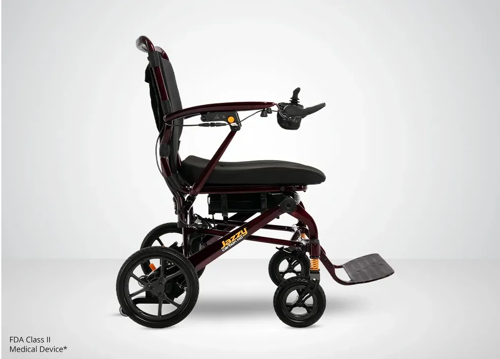 Black foldable wheelchair with headrest, armrest, and footplate, shown in profile on a white background