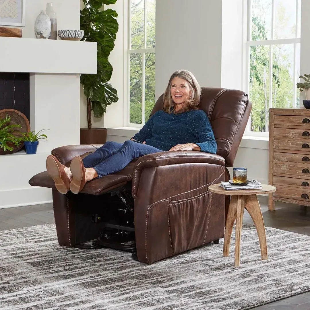 Woman relaxing in a brown leather recliner beside a small side table in a bright living room