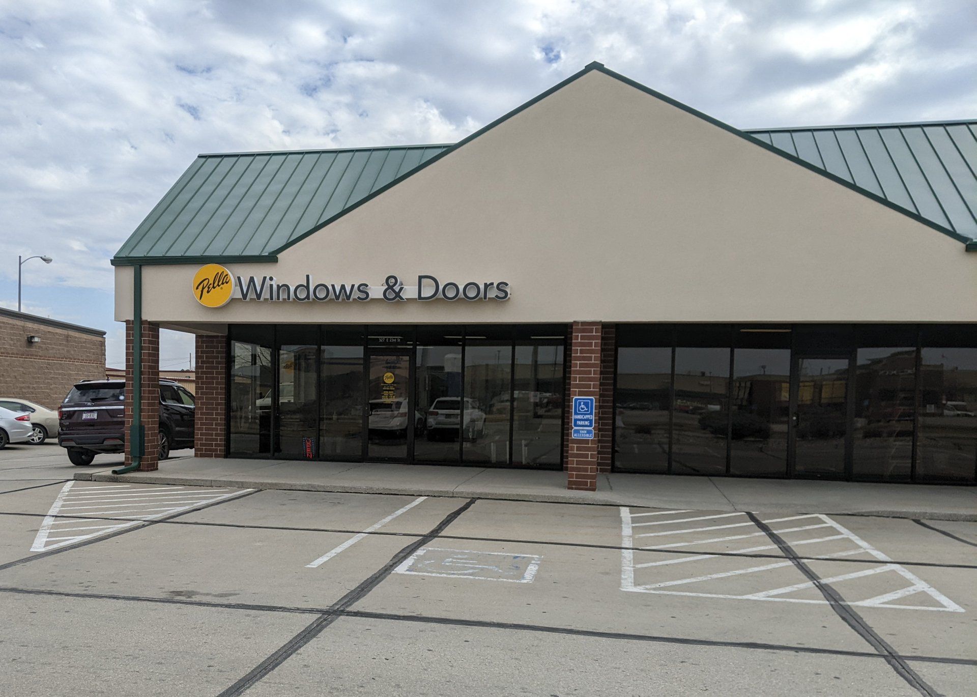 A building with a green roof and a sign that says windows and doors