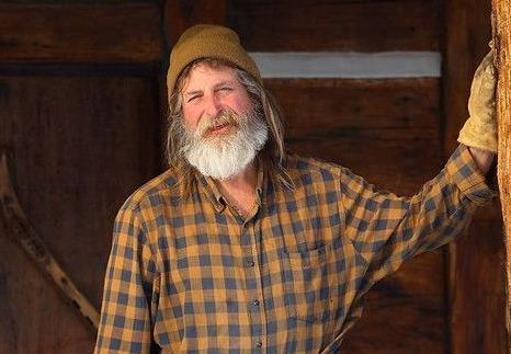 Mike Bailey standing on cabin porch.