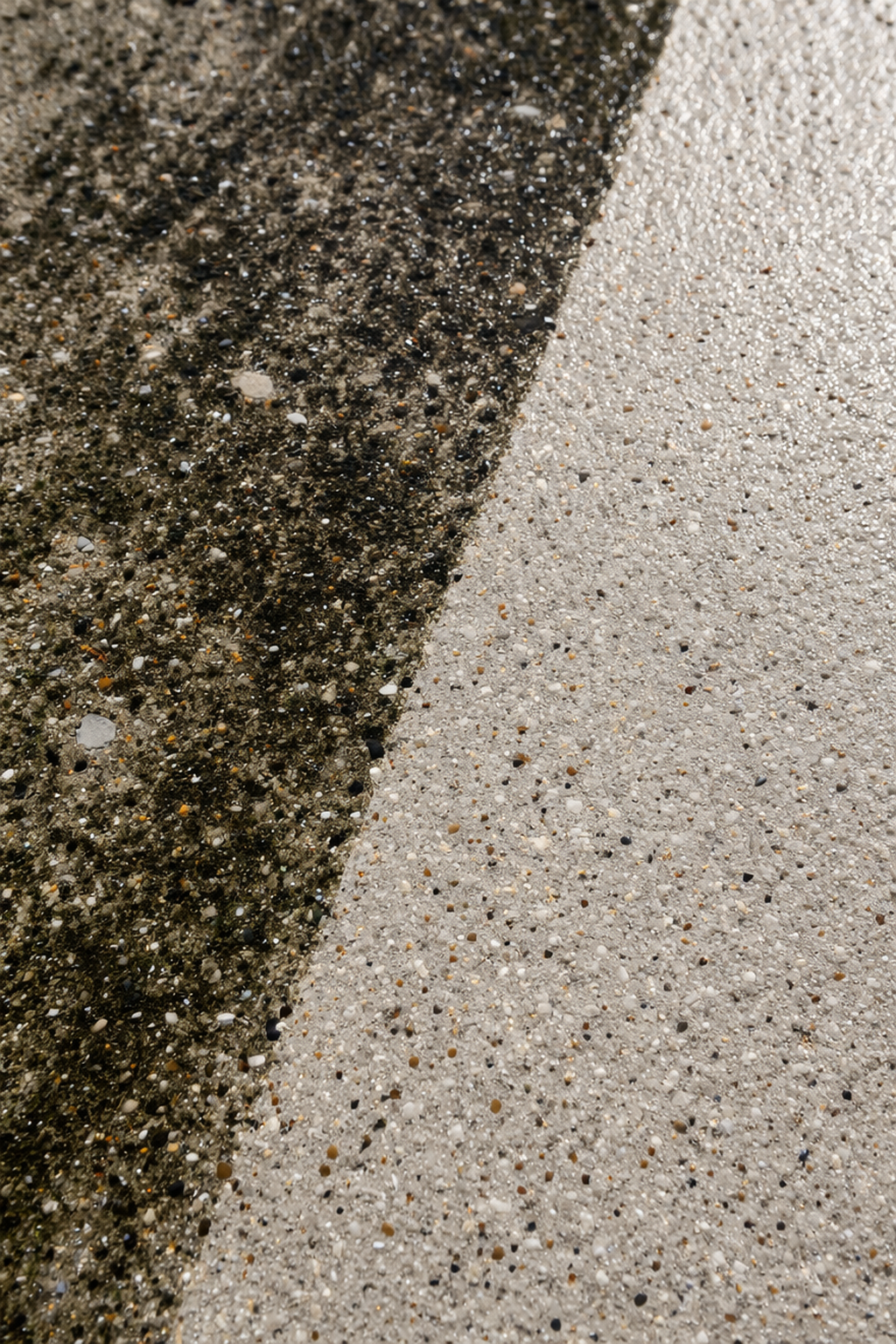 A split-view showing a diagonal transition from dark, dirty, mossy concrete to clean, light-colored concrete.