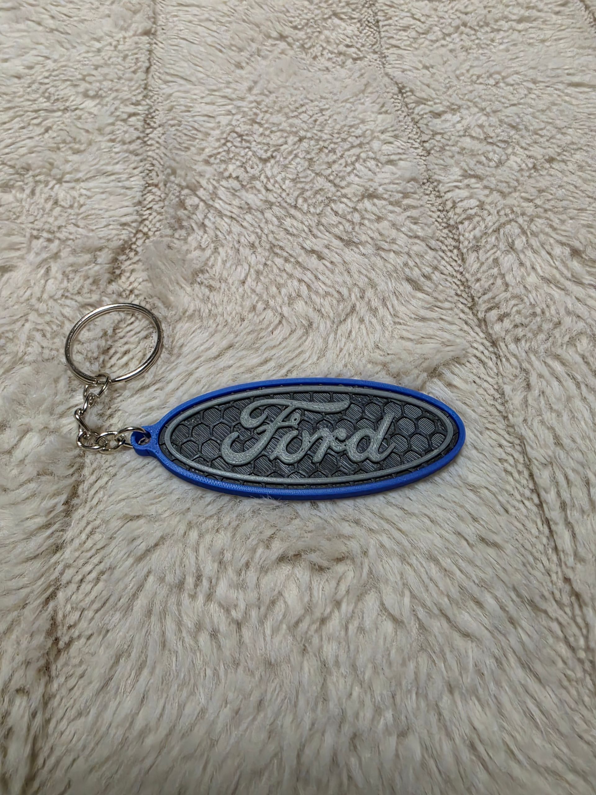 Sleutelhanger met Ford-logo op een donkere stoffen achtergrond