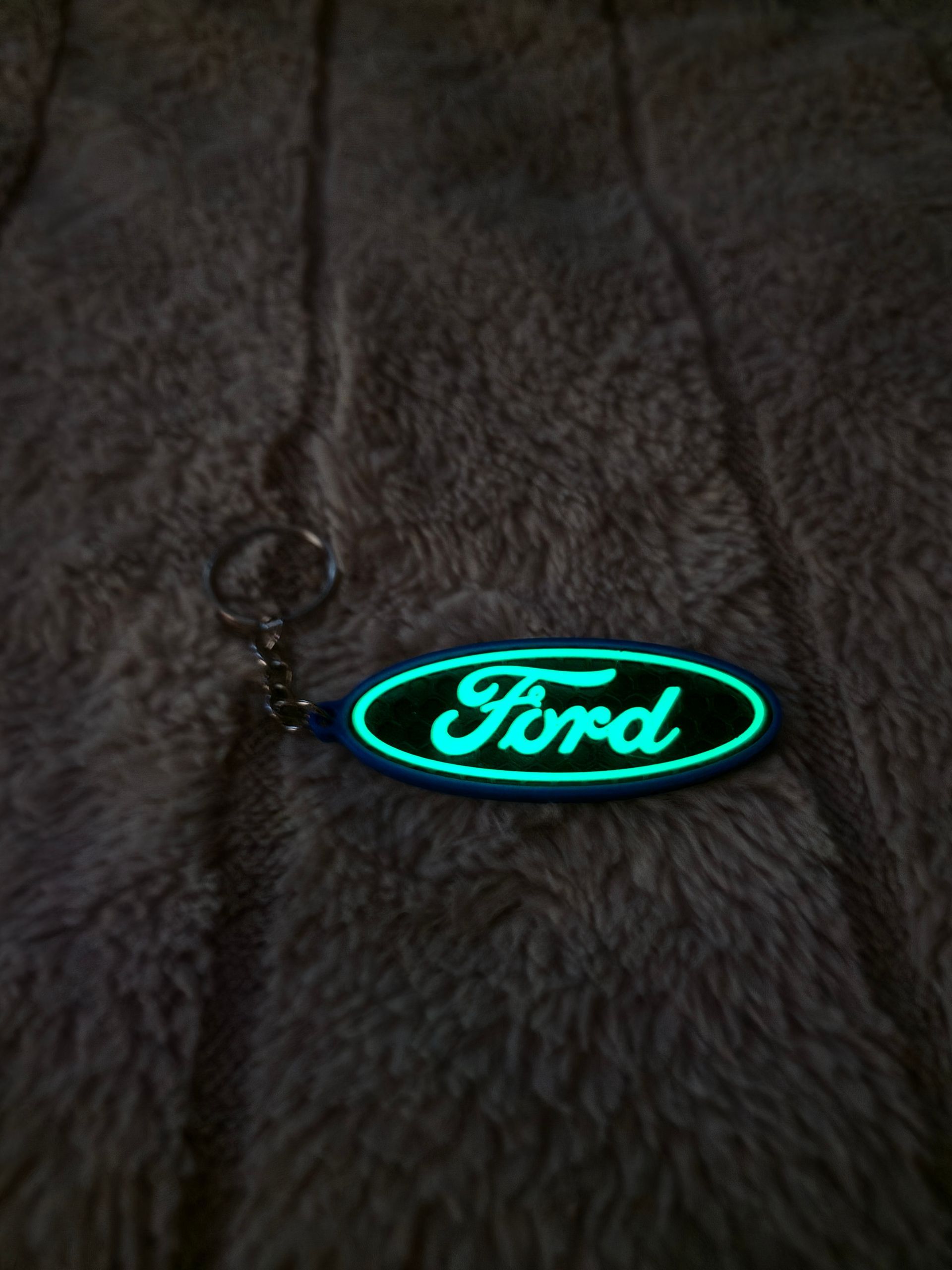 Sleutelhanger met Ford-logo op een donkere stoffen achtergrond