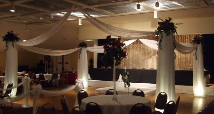 A large room with tables and chairs decorated for a wedding reception