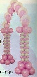 A bunch of pink balloons are sitting on top of each other on a table.