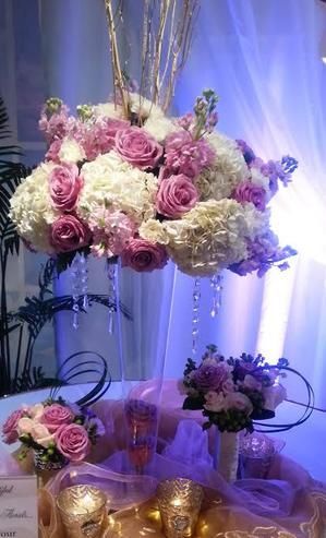 A table decorated with pink and white flowers and candles.