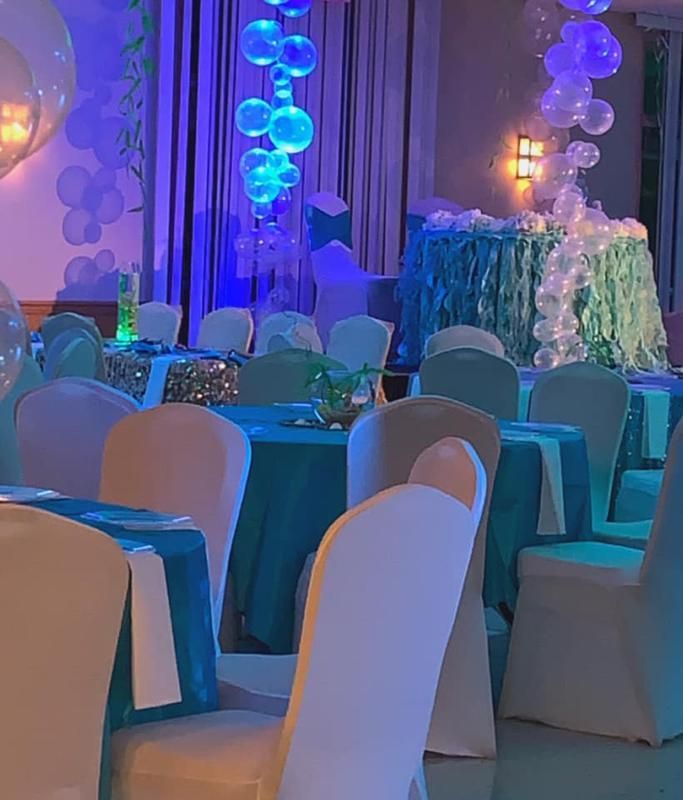 A room with tables and chairs and balloons hanging from the ceiling