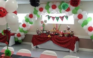 A room decorated with balloons and flowers for a ladybug birthday party.