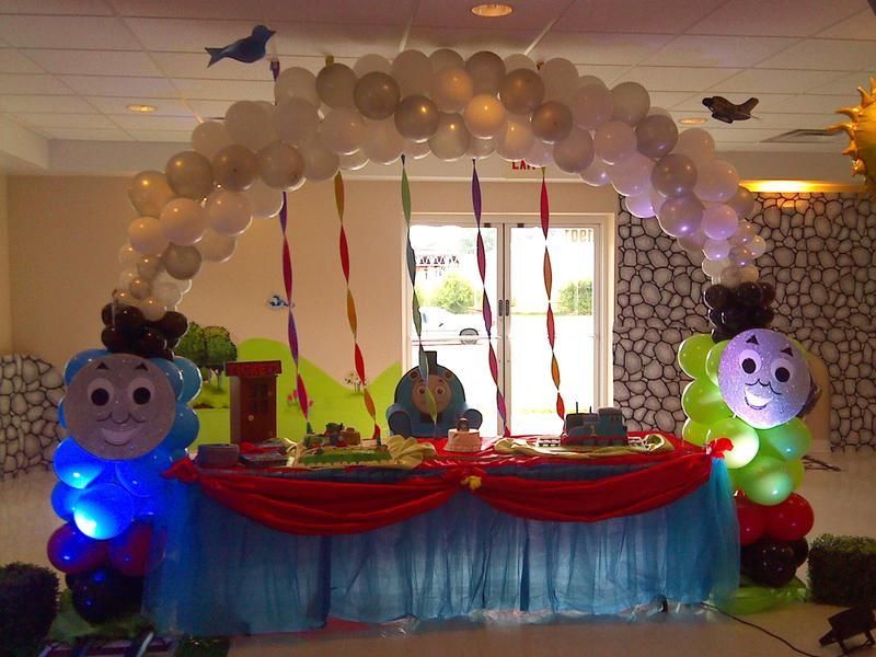 A table is decorated with thomas the train balloons