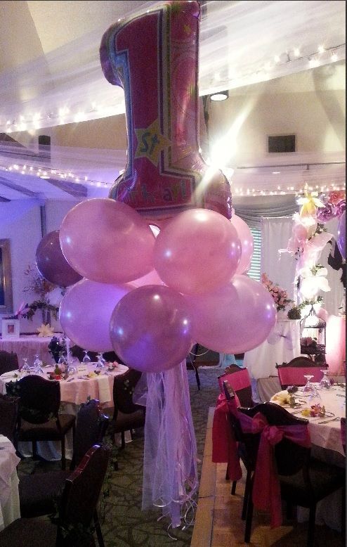 A bunch of pink balloons with the number 1 on top