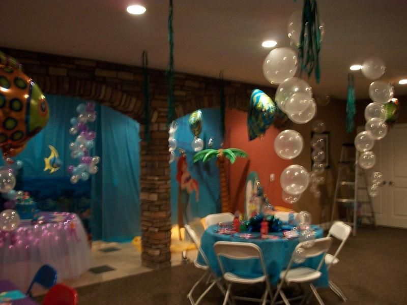 A room with tables and chairs and balloons hanging from the ceiling