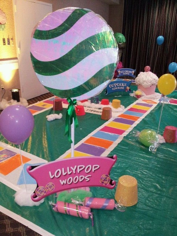 A lollipop woods table with balloons and candy