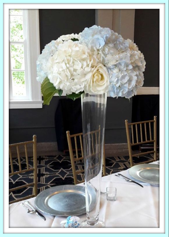 A vase filled with white and blue flowers sits on a table