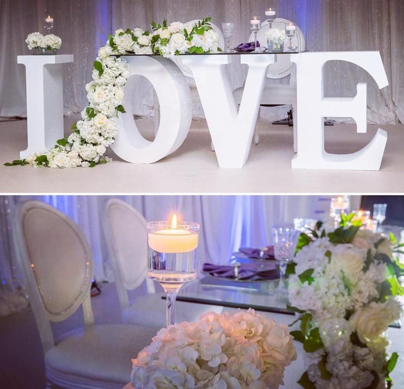 The word love is on a table with flowers and candles