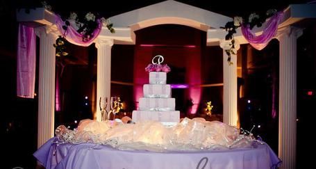 A wedding cake is sitting on a table under a gazebo