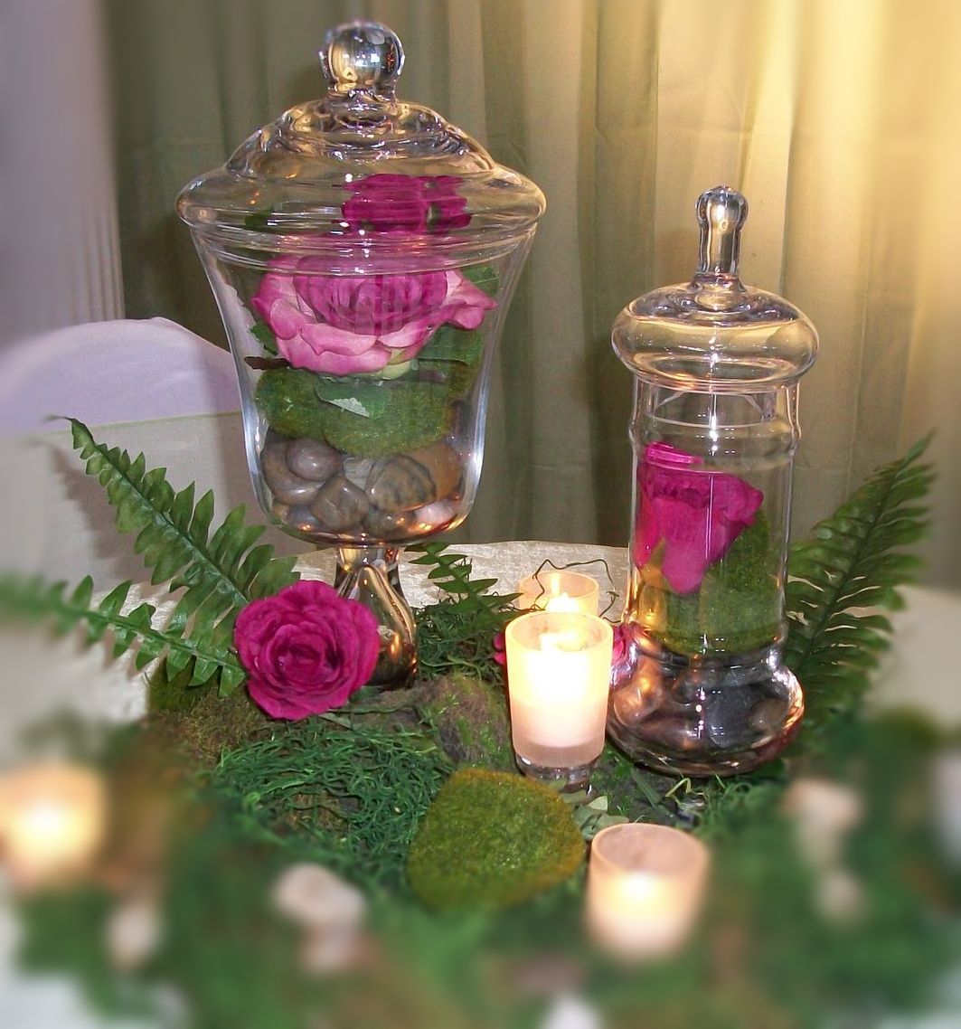 A table with a vase of flowers and candles on it
