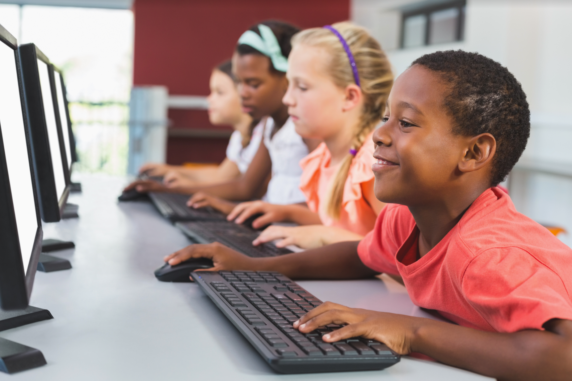 A group of children are using computers in a classroom.