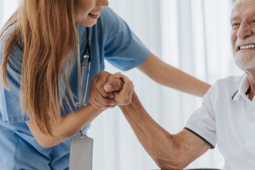 Un operatore sanitario somministra un'iniezione nella parte superiore del braccio di un paziente.
