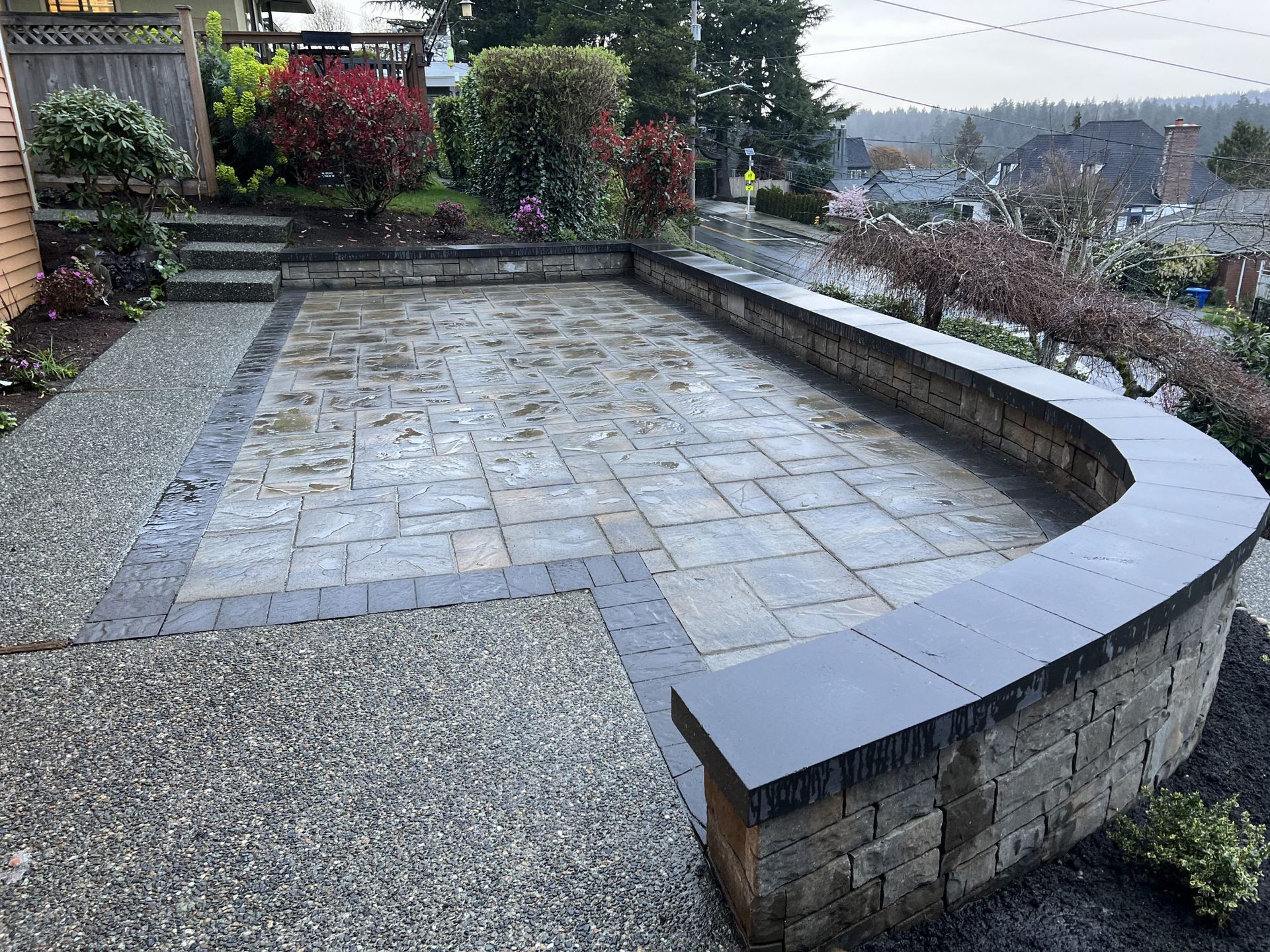A patio with a brick wall and a bench in Monroe, WA.