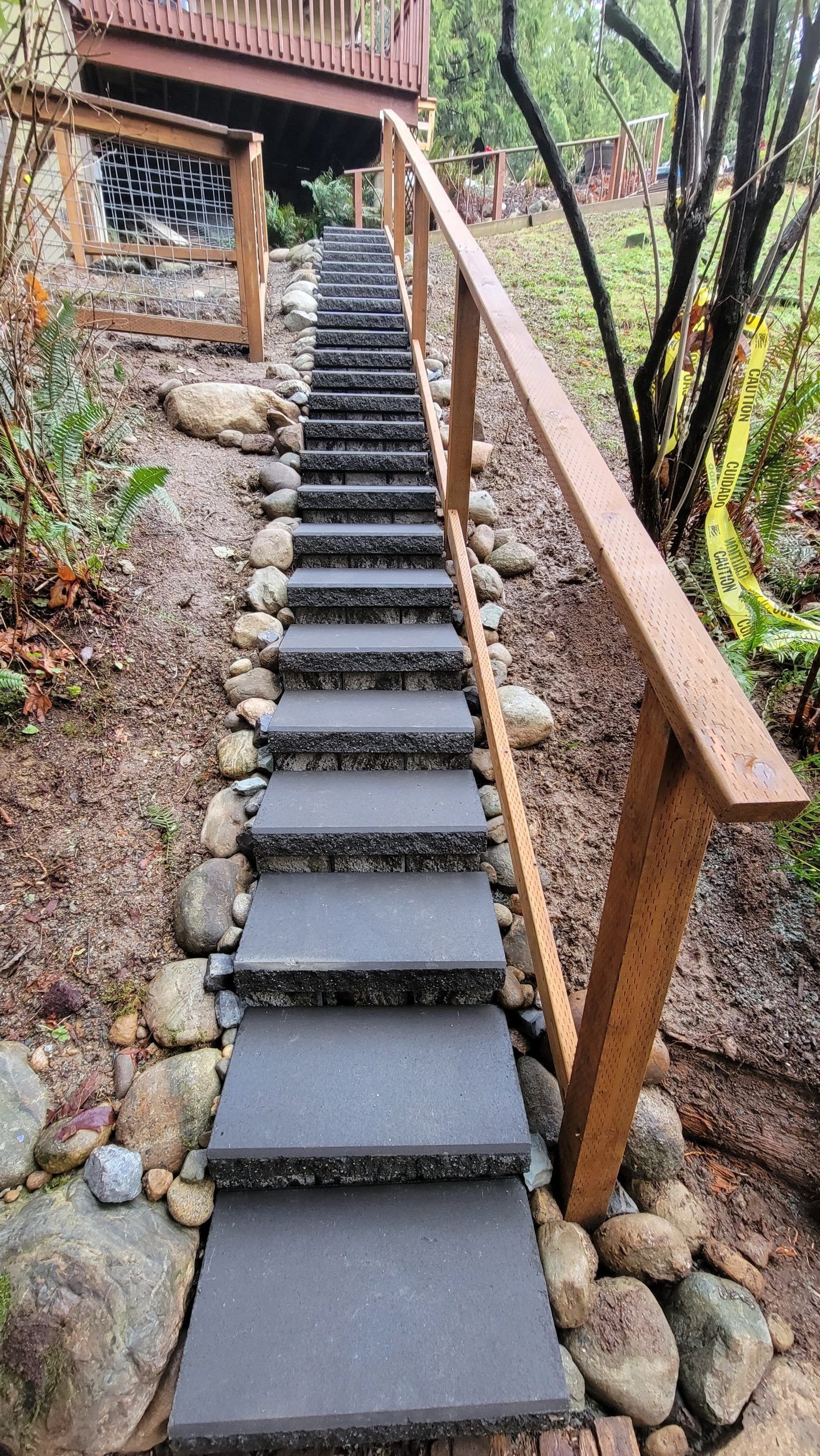 A set of stairs leading up to a house with a wooden railing in Monroe, WA.