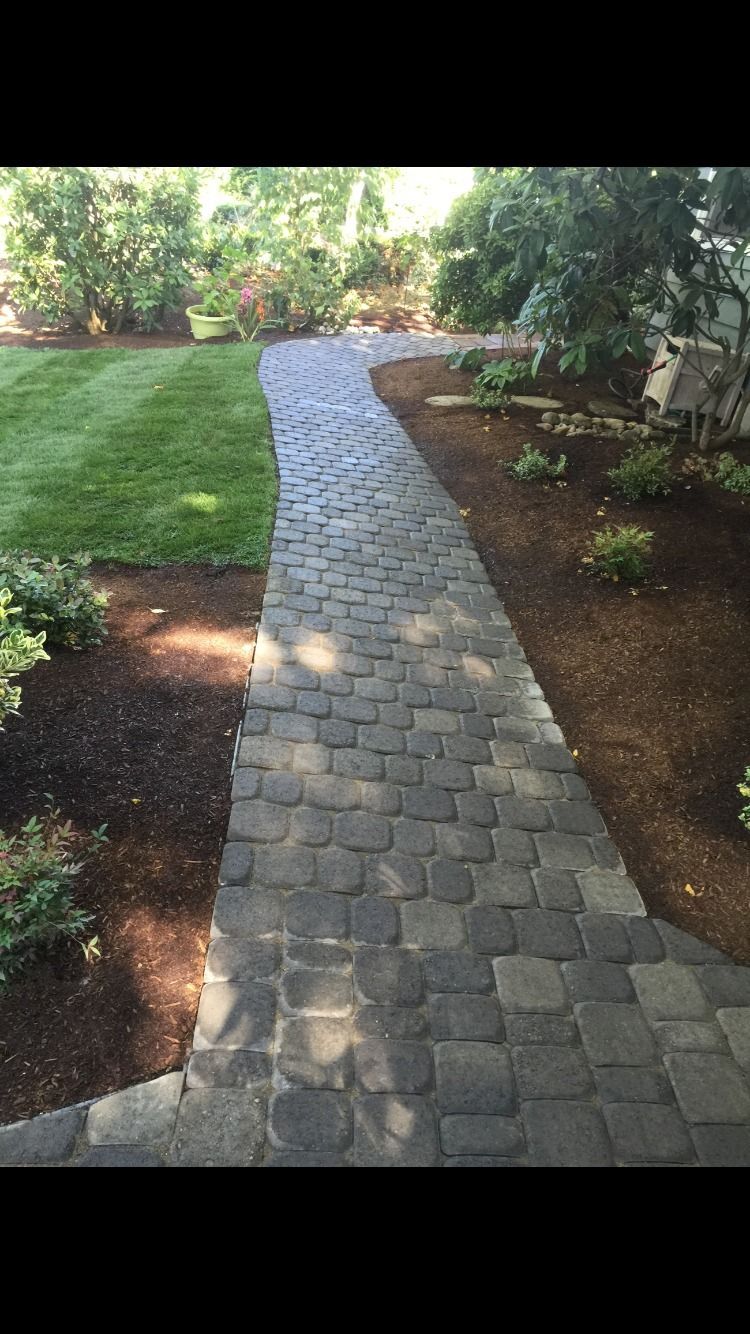 A stone walkway leading to a lush green yard in Monroe, WA.