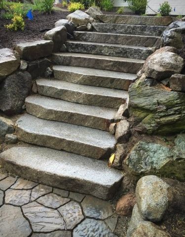A set of stone stairs surrounded by rocks in a garden.