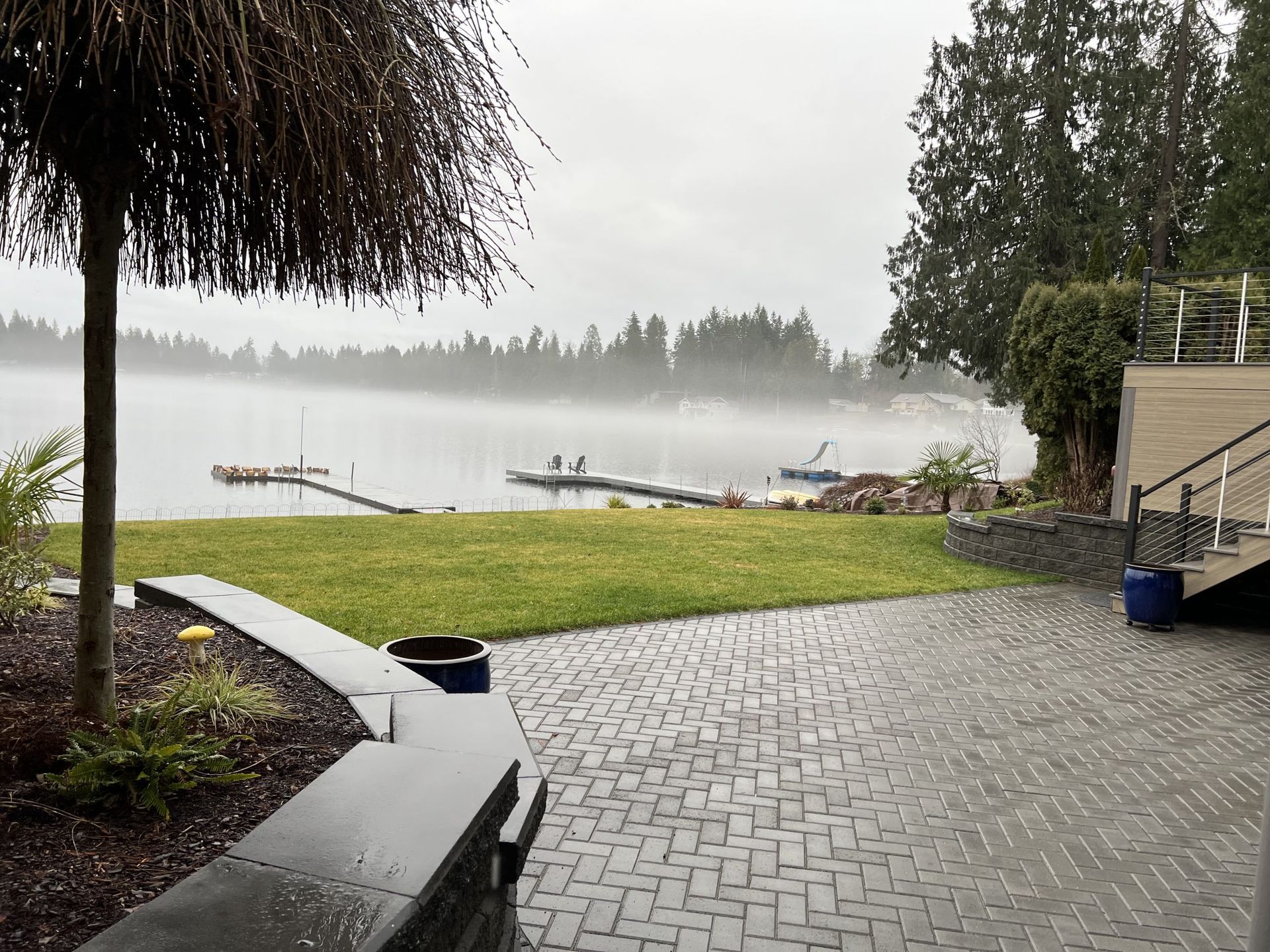 A patio with a view of a lake on a cloudy day