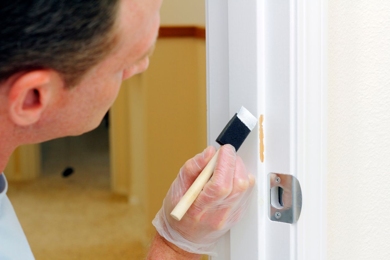 A man is painting a door with a brush.