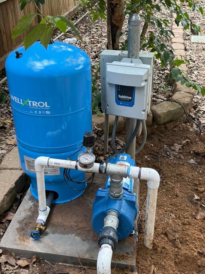 Blue well pump system with pressure tank and control box outdoors.