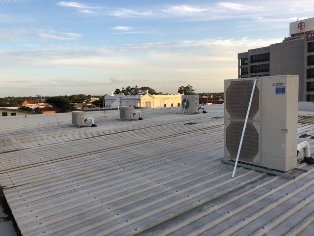 Air Compressors Are Installed At The Wall - Air Conditioning Services in Mackay, QLD Air Conditioning Unit on Commercial Property Roof - Air Conditioning Services in Mackay, QLD