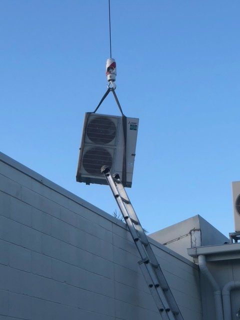 Technician Repairing Outdoor Air Conditioner Unit - Air Conditioning Services in Mackay, QLD Outdoor Air Conditioner Unit Install - Air Conditioning Services in Mackay, QLD