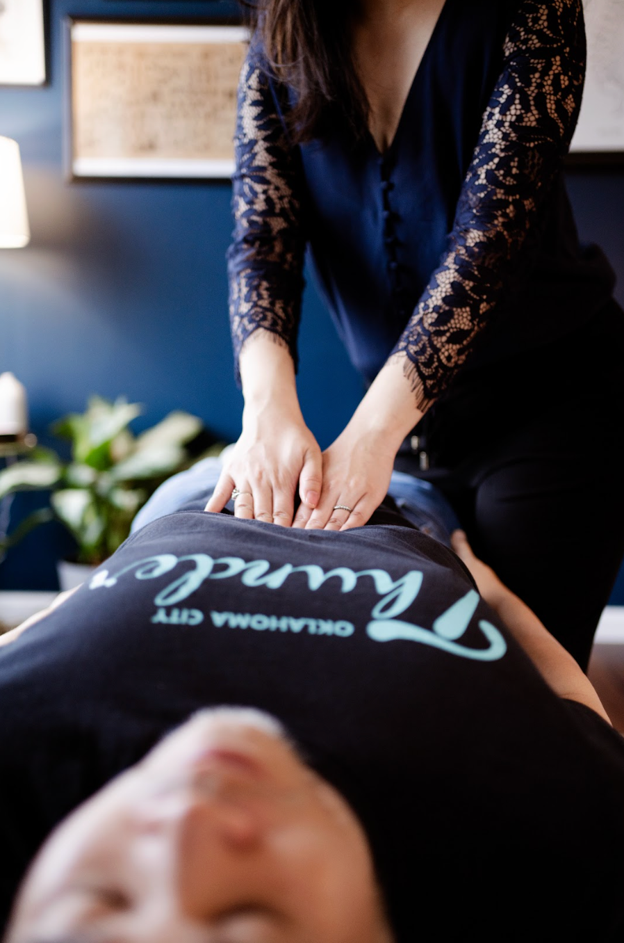 Massage therapist giving back massage with hands on client in spa room
