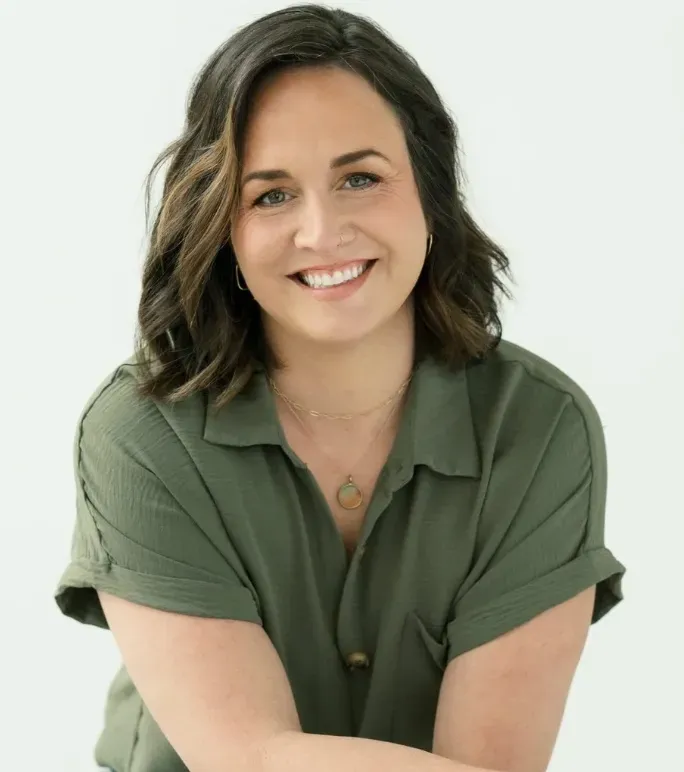 Smiling woman in a green blouse against a light background